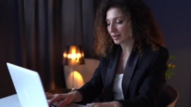Gece geç saatlerde ofiste dizüstü bilgisayar kullanan konsantre olmuş ciddi bir iş kadınının portresini kapat. Aşırı çalışma kavramı