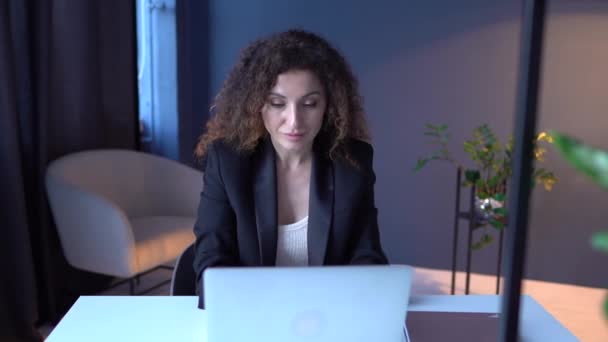 Remote employment and freelance concept. Attractive adult woman working on laptop in a cozy coworking workspace — Stock Video