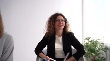 Farklı yaşlardaki kadınlar psikolog ya da antrenör ofisinde yaptıkları terapi toplantısında konuşurlar ve deneyimleri ve desteği paylaşırlar.