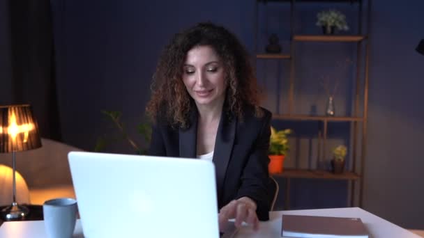 Donna attraente che lavora fino a tardi la notte a casa. Donna d'affari beve tè durante l'utilizzo di un computer portatile. Lavoro a distanza, concetto di home office — Video Stock