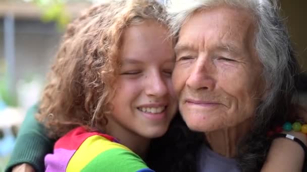 Portrait rapproché d'une petite-fille et d'une grand-mère. Adolescente étreint son arrière-grand-mère. Deux femmes, jeunes et vieux s'embrassent — Video