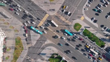 Moskova 'da trafiğin yoğun olduğu büyük bir kavşağın üst görüntüsü. Kamera yukarı doğru hareket ediyor. Trafik ışıklarında bekleyen diğer araçlar kavşakta farklı yönlerde dönerken birçok arabayı gösteriyor..
