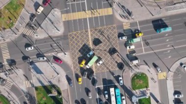 Moskova 'da trafiğin yoğun olduğu büyük bir kavşağın üst görüntüsü. Kamera yukarı doğru hareket ediyor. Trafik ışıklarında bekleyen diğer araçlar kavşakta farklı yönlerde dönerken birçok arabayı gösteriyor..