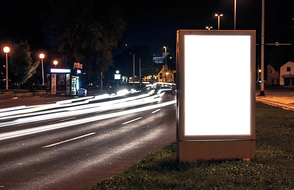 Tabellone per le affissioni nella strada della città di notte, schermo bianco — Foto Stock