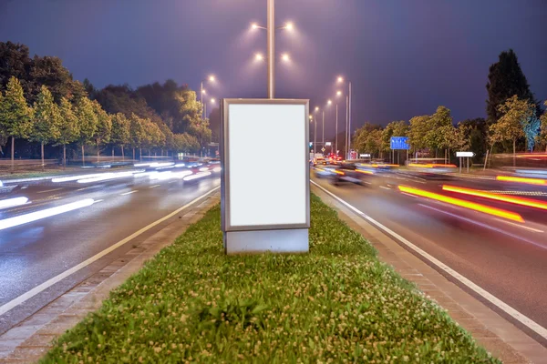 Billboard en la calle de la ciudad por la noche, pantalla en blanco — Foto de Stock