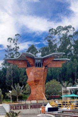 12 Şubat 2025 'te Kolombiya Zipaquira, Parque de la Sal' daki Plaza del Minero üzerinde çarpıcı bir ahşap tırmanma kulesi, modern tasarımı orman tepeleriyle harmanlayarak canlı bir gökyüzü altında yükselir..