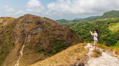 El Valle de Anton, Panama. 16 Şubat 2024. Yürüyüşçüler, güneşli bir günde, sarp tepelere ve vadilere bakan La India Dormida dağ yolu boyunca dururlar..