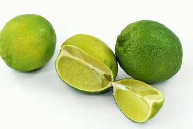 Açık arkaplanda yeşil dilimlenmiş limon.