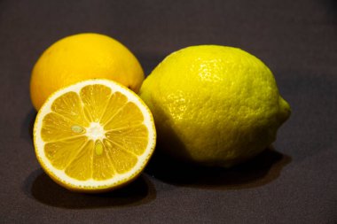 Koyu bir arka planda üç olgun limon