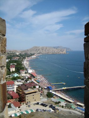 Yüksek bir noktadan deniz kenti manzarası. Seyahat sezonunda şehir ve sahil manzarası.