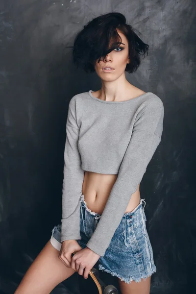 Funky girl posing with skateboard — Stock Photo, Image