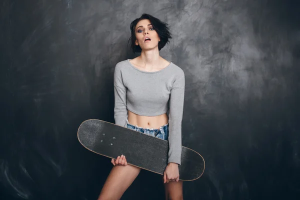 Beautiful Young sporty woman with skateboard — Stock Photo, Image