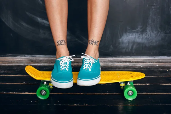 Beine eines jungen Mädchens auf dem Longboard. Skateboarden — Stockfoto