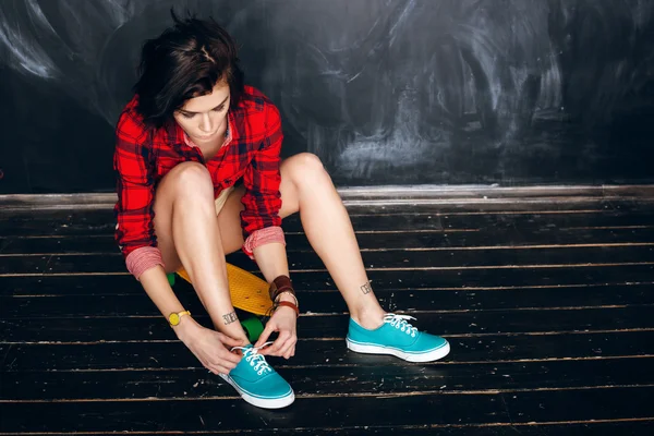 Mulher a atar atacadores. Pronto para andar de skate — Fotografia de Stock