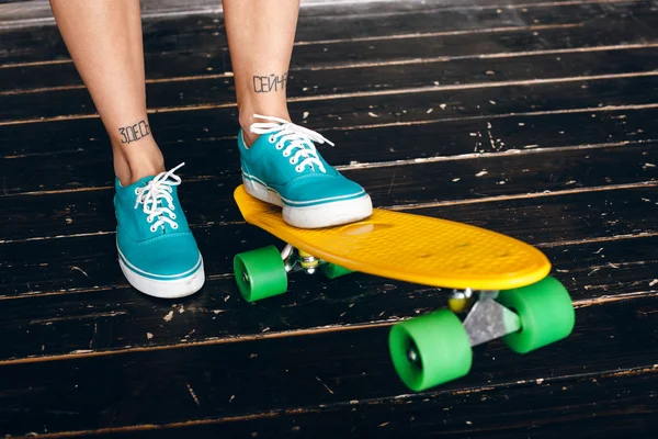 Benen van het jonge meisje op longboard. Skateboarden — Stockfoto