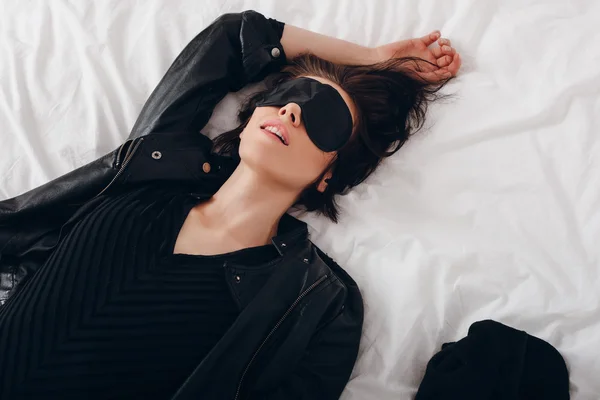 Dziewczyna z maską dla snu leżąc w łóżku — Zdjęcie stockowe