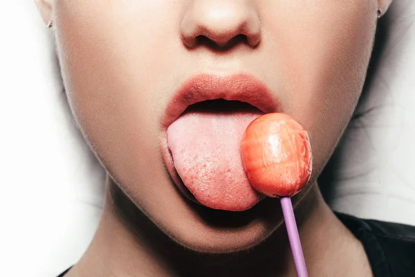 Vrouw likken rood glanzend lollipop — Stockfoto