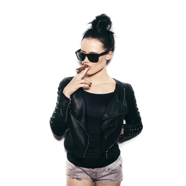 Jeune femme sexy en lunettes de soleil et veste en cuir noir fumant cigare — Photo