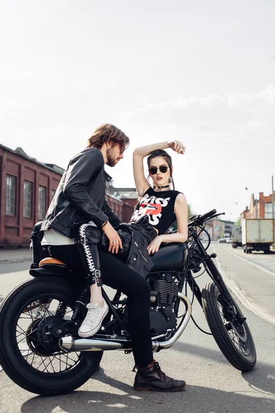 young couple sitting on vintage motorcycle