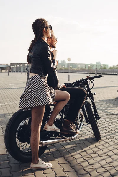 Casal sentado na motocicleta ao pôr do sol — Fotografia de Stock