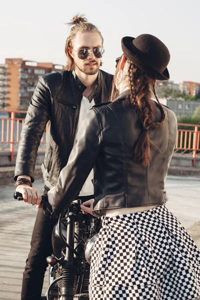 Молодая пара сидит на винтажном мотоцикле — стоковое фото