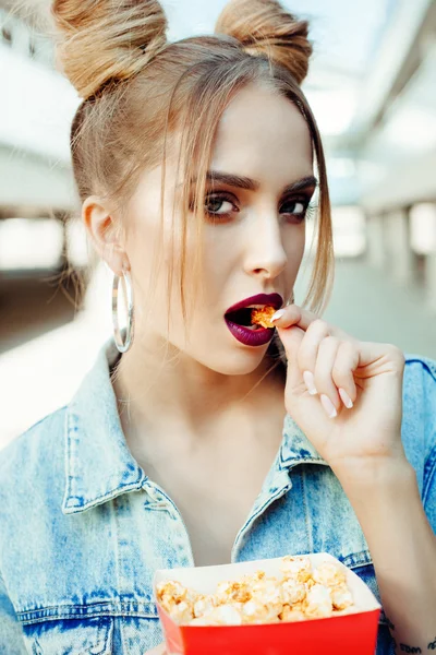 Porträt einer glücklichen jungen Frau, die Popcorn isst — Stockfoto