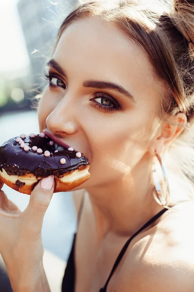 Retrato de chica hermosa divertida comiendo donut — Foto de Stock