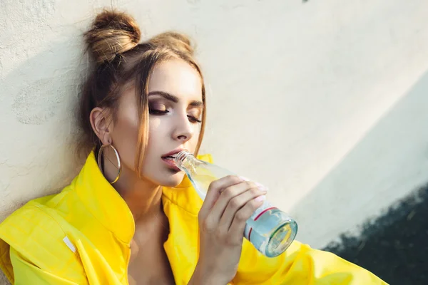 beautiful cheeky girl drinking water in park