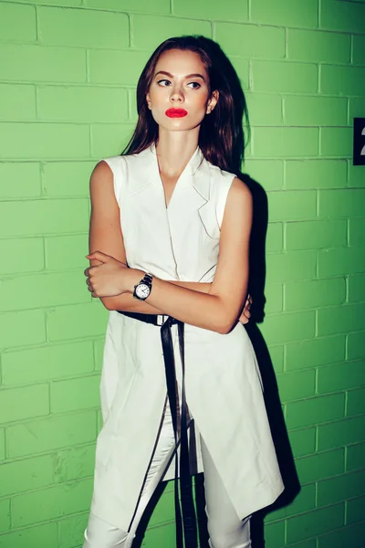 Trendy Hipster kız ayakta yeşil tuğla duvar — Stok fotoğraf
