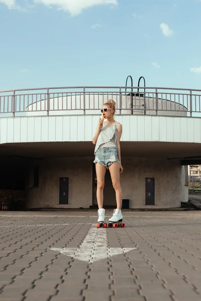 Beautiful girl with ice cream on rollers in city — Stock Photo, Image