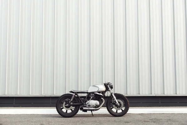 Moto debout dans le bâtiment sombre dans les rayons du soleil — Photo