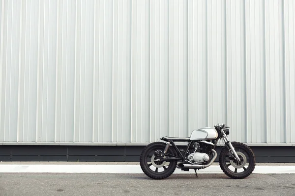 Moto debout dans le bâtiment sombre dans les rayons du soleil — Photo