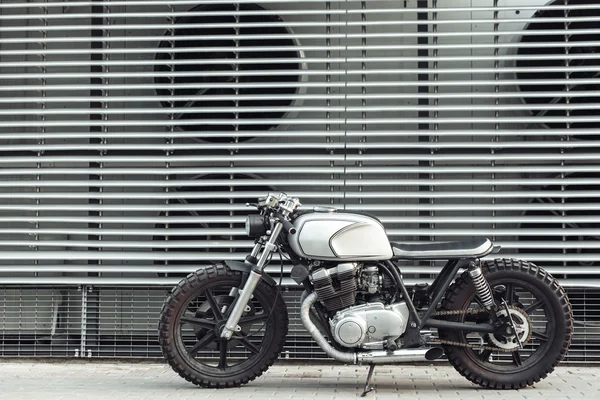 Moto debout dans le bâtiment sombre dans les rayons du soleil — Photo