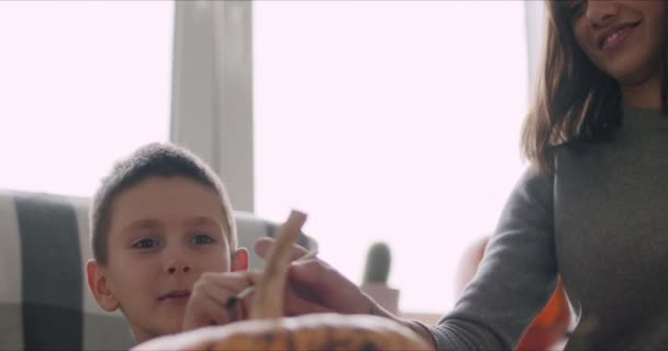 Woman with son paint pumpkin for Halloween — Stock Video