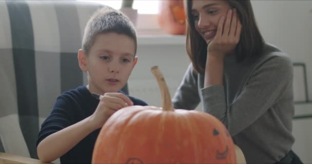 Mulher com filho pintar abóbora para Halloween — Vídeo de Stock