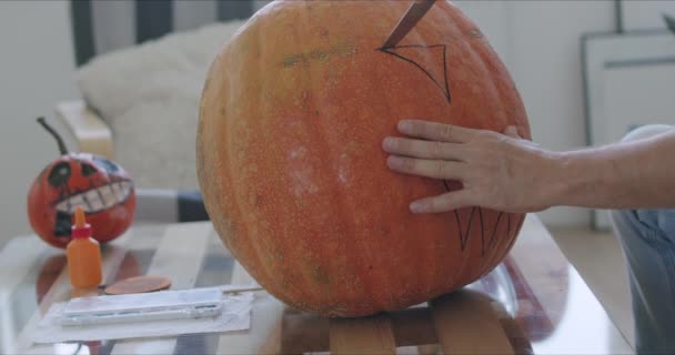 Manos masculinas tallando agujeros en calabaza — Vídeos de Stock