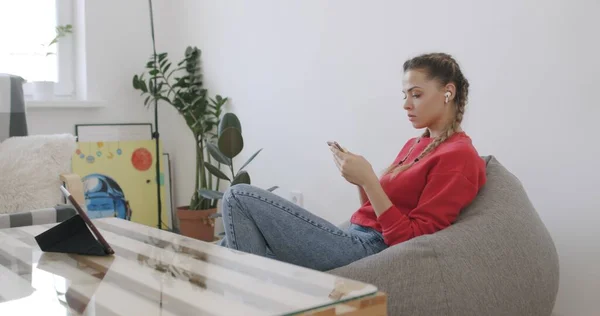 Chica sentada en casa y hablando por teléfono —  Fotos de Stock