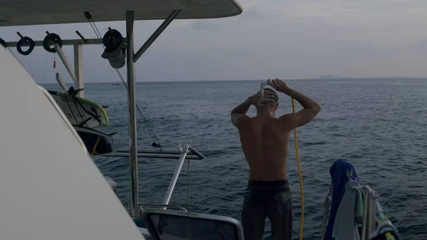 Νεαρός άνδρας που κάνει ντους και μπλε ωκεανό στο παρασκήνιο — Φωτογραφία Αρχείου