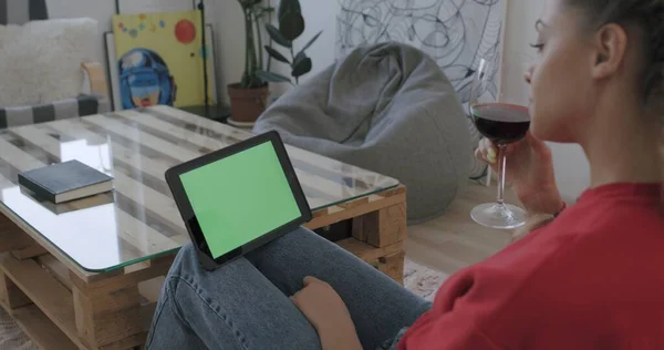 Женщина держит планшетный компьютер с зеленым экраном — стоковое фото