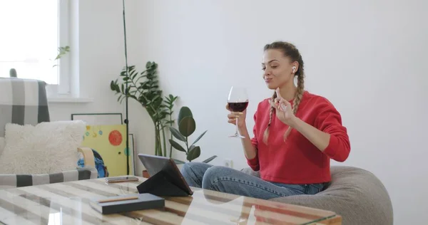 Женщина выпивает бокал вина во время разговора с другом — стоковое фото