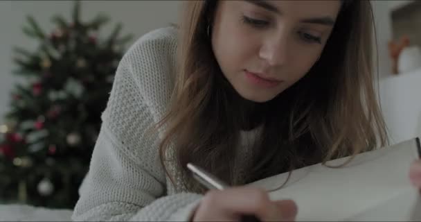 Děvče si dělá poznámky do sešitu — Stock video