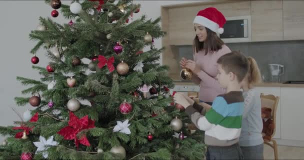 Щаслива родина упаковує різдвяні подарунки — стокове відео