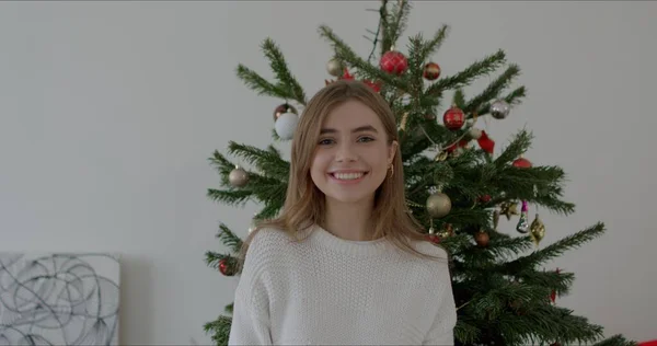 Mujer en ropa de abrigo en el fondo del árbol de Navidad — Foto de Stock