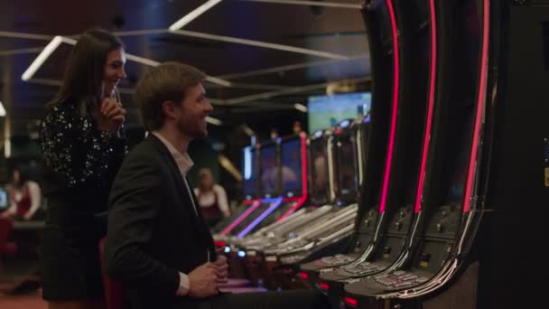 Pareja jugando máquina tragaperras en el casino — Vídeos de Stock