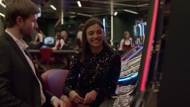 Pareja jugando máquina tragaperras en el casino — Vídeos de Stock