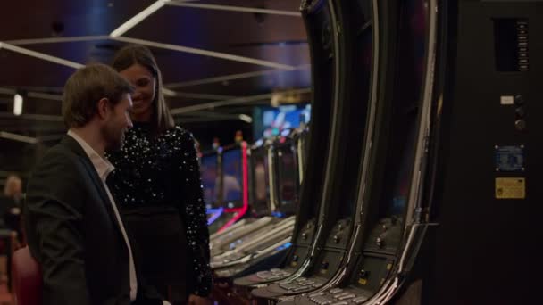 Pareja jugando máquina tragaperras en el casino — Vídeos de Stock