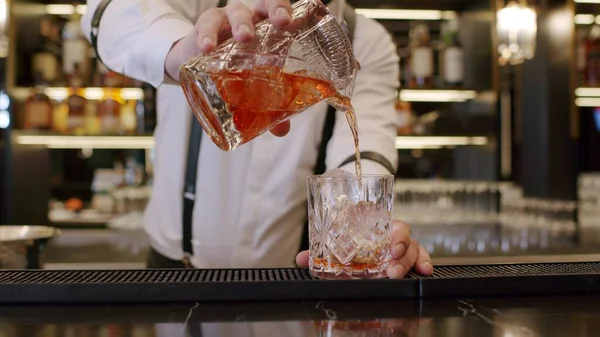 bartender mixing cocktail at bar