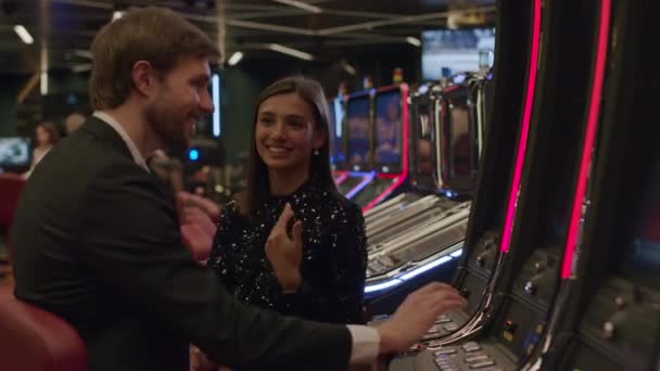 Couple playing slot machine in casino — Stock Video