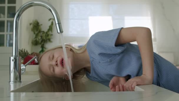 Kız musluk suyu içmeye çalışıyor. — Stok video