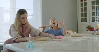 girl rolling dough on kitchen table clipart
